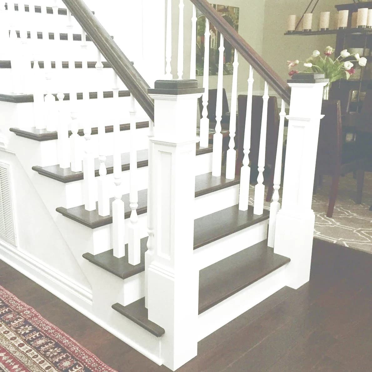 Ohio-style staircase with white paneled box newels and white turned balusters on dark treads