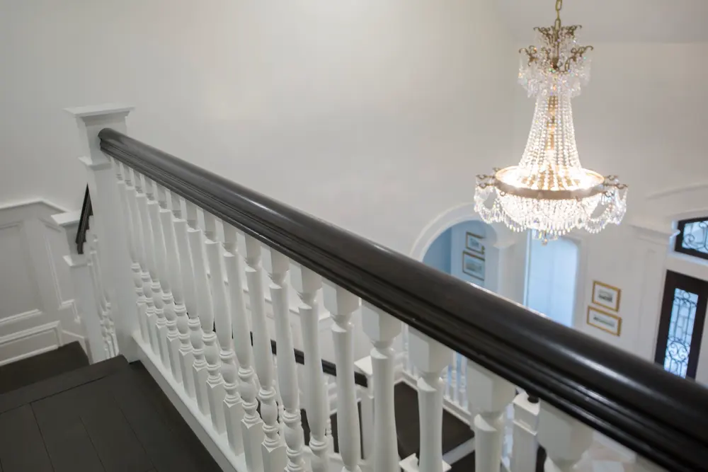 Ebonized rail and white turned balusters Snyder Stairs hung on the Caruso balcony